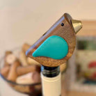 Wooden bird-shaped bottle stopper on a bottle with blurred background