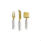Set of three cheese tools with gold blades and white marble handles on a white background
