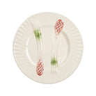 A white ceramic plate with a fluted rim, featuring two clear plastic utensils embedded in the center, each with a red grid pattern and a green translucent section.