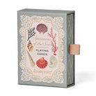 Playing card set packaging with seashell and coral design on a white background