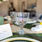 Decorative glass goblet on a table with place cards and cutlery