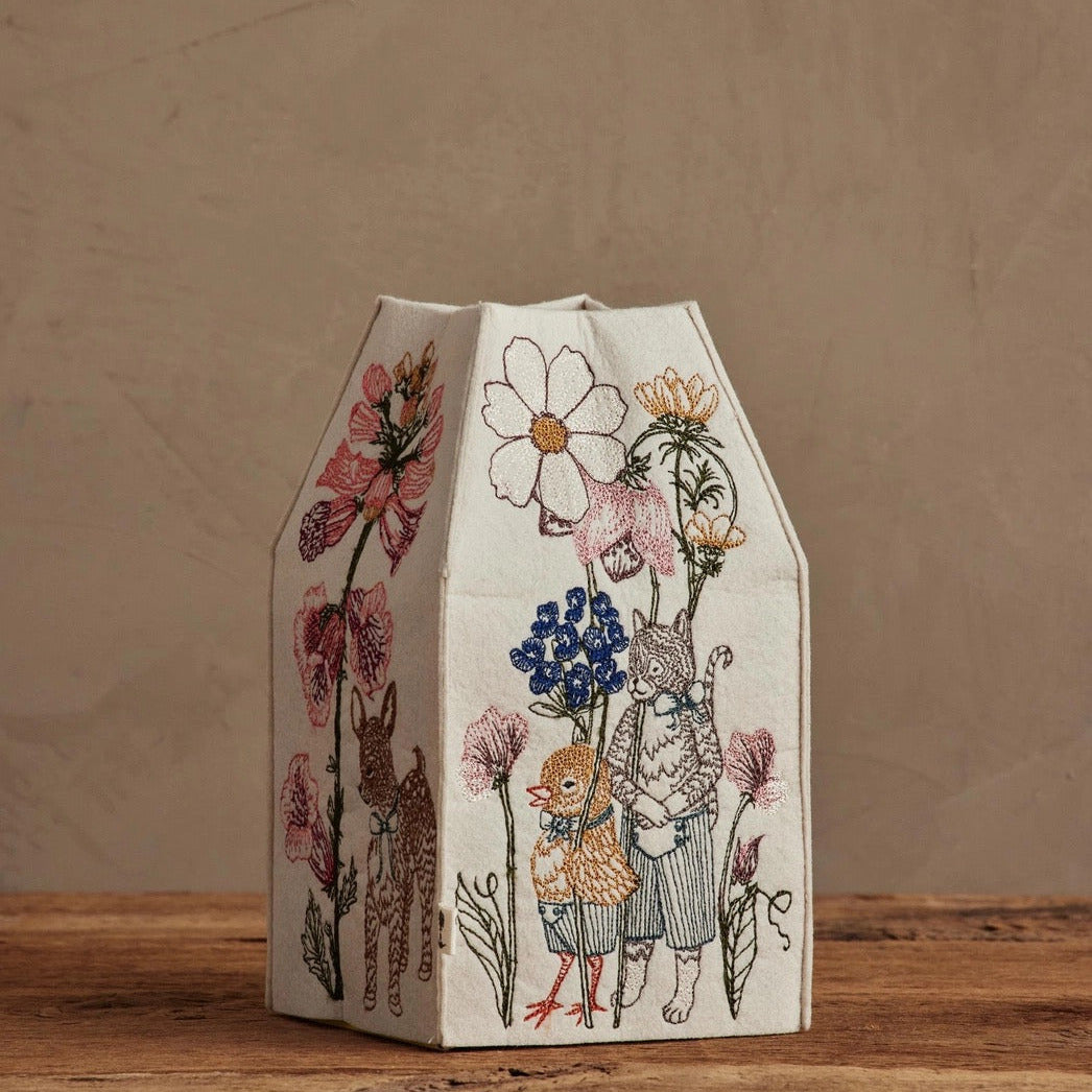 Decorative box with animal and floral illustrations on a wooden surface.
