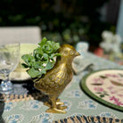 Gold bird-shaped planter with succulents on a decorative table