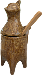 Brown ceramic container with lid and wooden handle on a white background