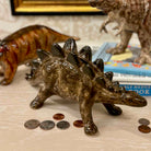 Dinosaur toy with coins on a surface