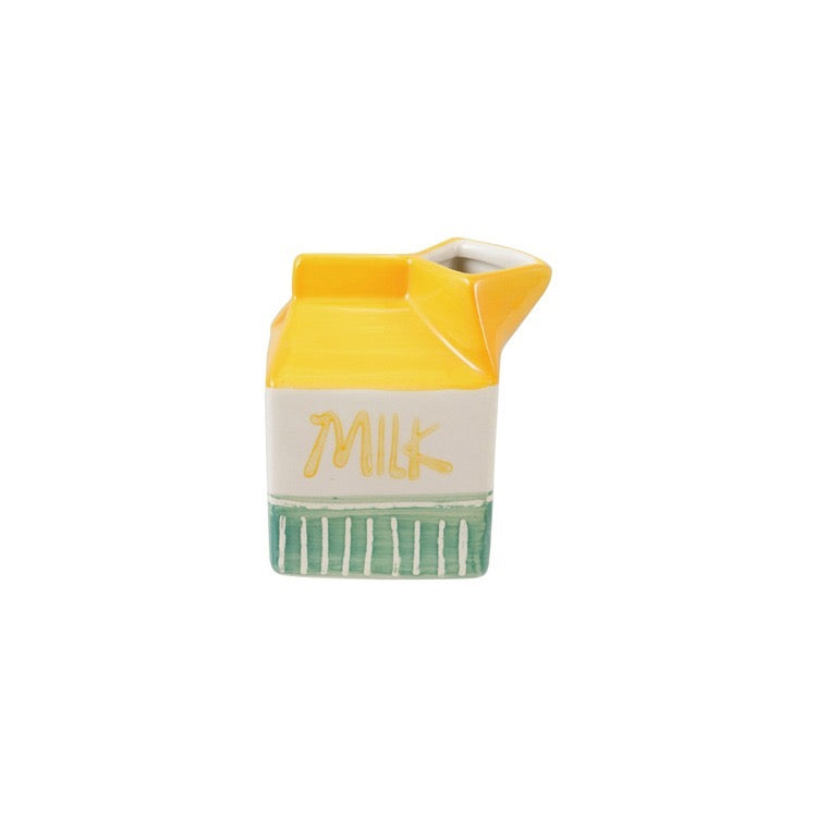 Ceramic milk carton-shaped container with yellow top and green bottom on a white background