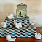 Decorative box with a seascape design on top, surrounded by snail-shaped objects.