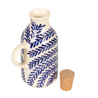 Ceramic oil dispenser with blue leaf pattern and cork stopper on a white background