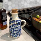 Ceramic bottle with blue leaf pattern on a kitchen counter