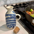 White ceramic pitcher with blue leaf pattern on a kitchen counter