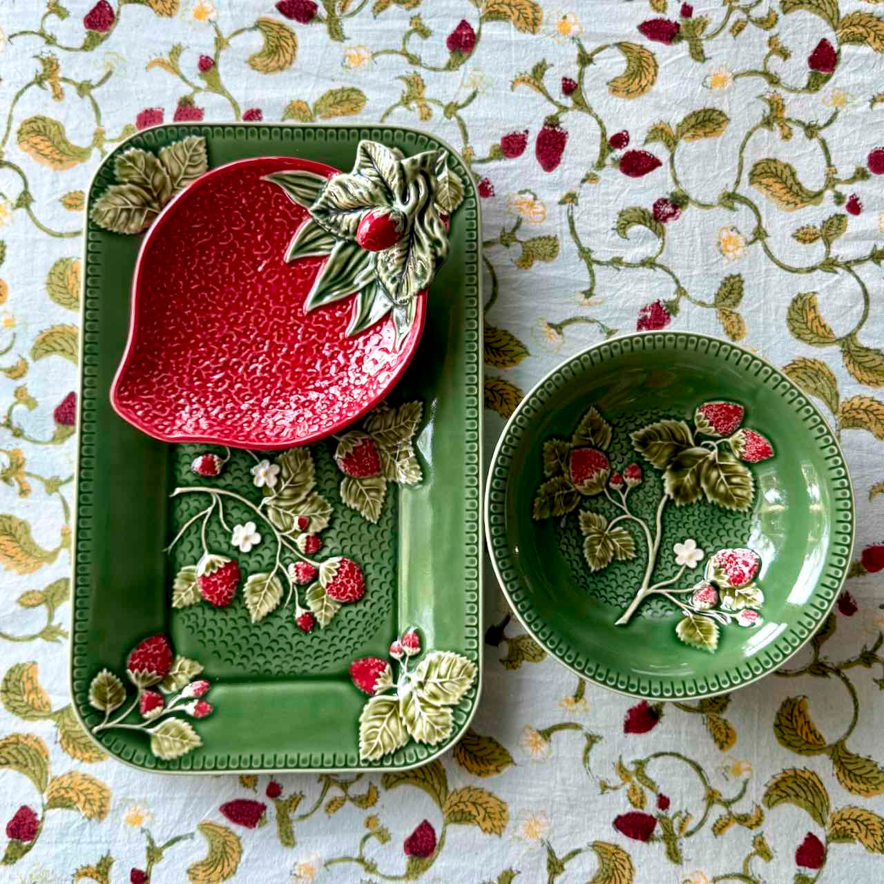Decorative ceramic items with floral designs on a patterned tablecloth