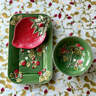 Decorative ceramic items with floral designs on a patterned tablecloth