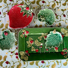 Decorative ceramic items with strawberry design on a patterned fabric background