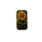 A small rectangular metal tin with a sunflower illustration on the lid, placed on a light wood surface.
