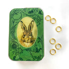 Decorative tin with rabbit illustration and gold rings on a white background