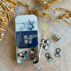 Metal tin with decorative items on a textured surface