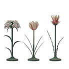 A set of three vintage-inspired metal flower candleholders in different designs, with a distressed green finish.