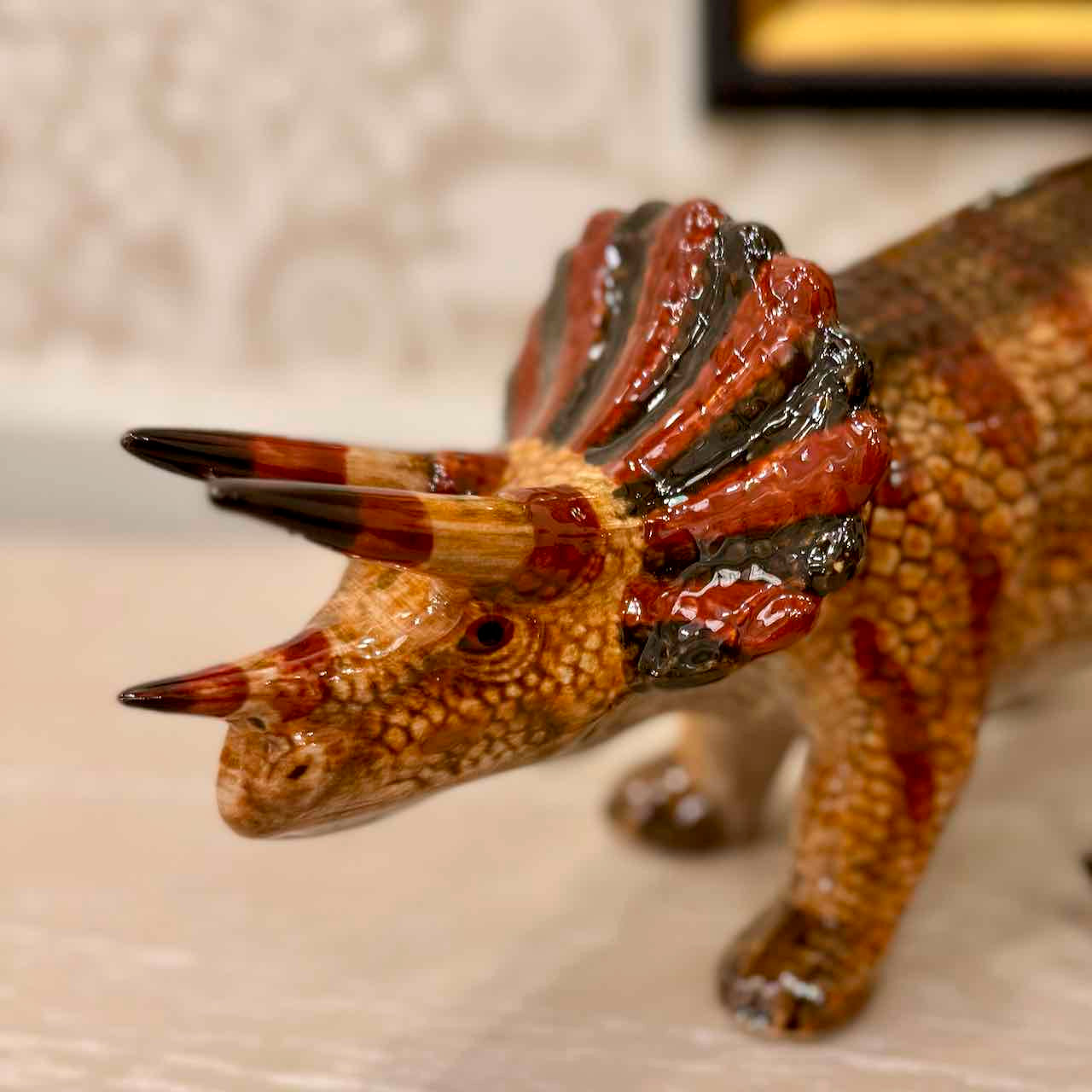 Dinosaur figurine with a textured surface on a neutral background