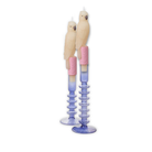 Two bird-shaped candles with pastel-colored candle holders on a white background
