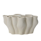 White ceramic vase with a textured, organic design on a white background
