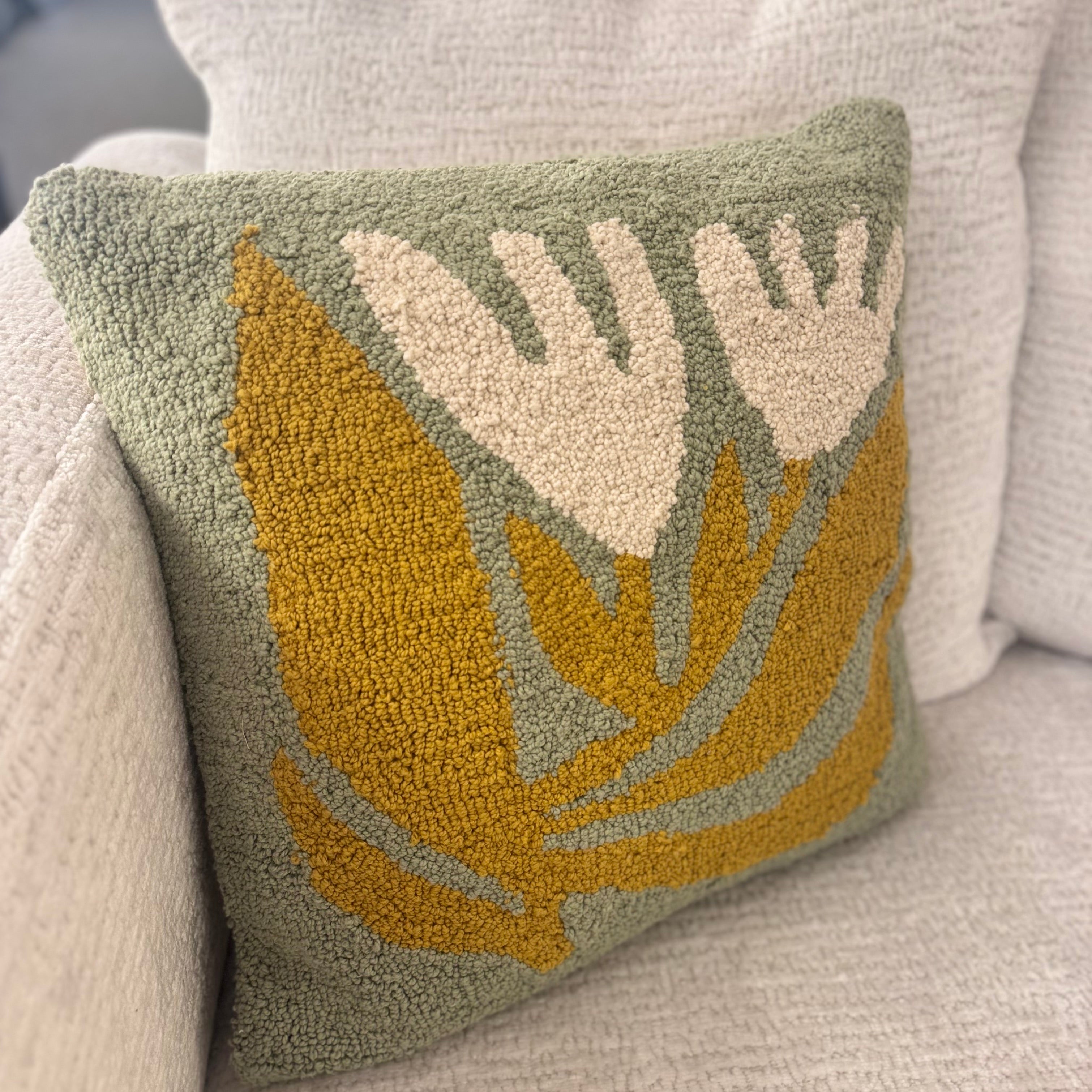 Decorative pillow with leaf pattern on a couch