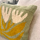 Decorative pillow with leaf pattern on a neutral background
