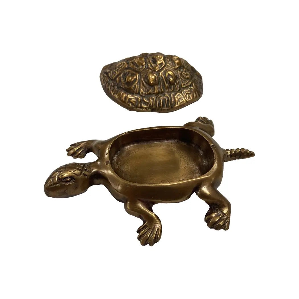Bronze turtle-shaped container with a smaller stone on a white background