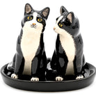 Ceramic cat-shaped salt and pepper shakers on a black base with a white background