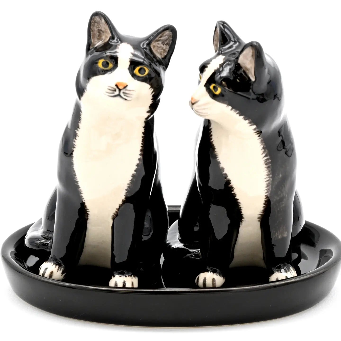 Ceramic cat-shaped salt and pepper shakers on a black base with a white background