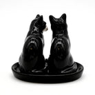 Black ceramic salt and pepper shakers shaped like dogs on a white background