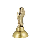 A small metallic gold figurine depicting praying hands on a round pedestal base, isolated on a white background.