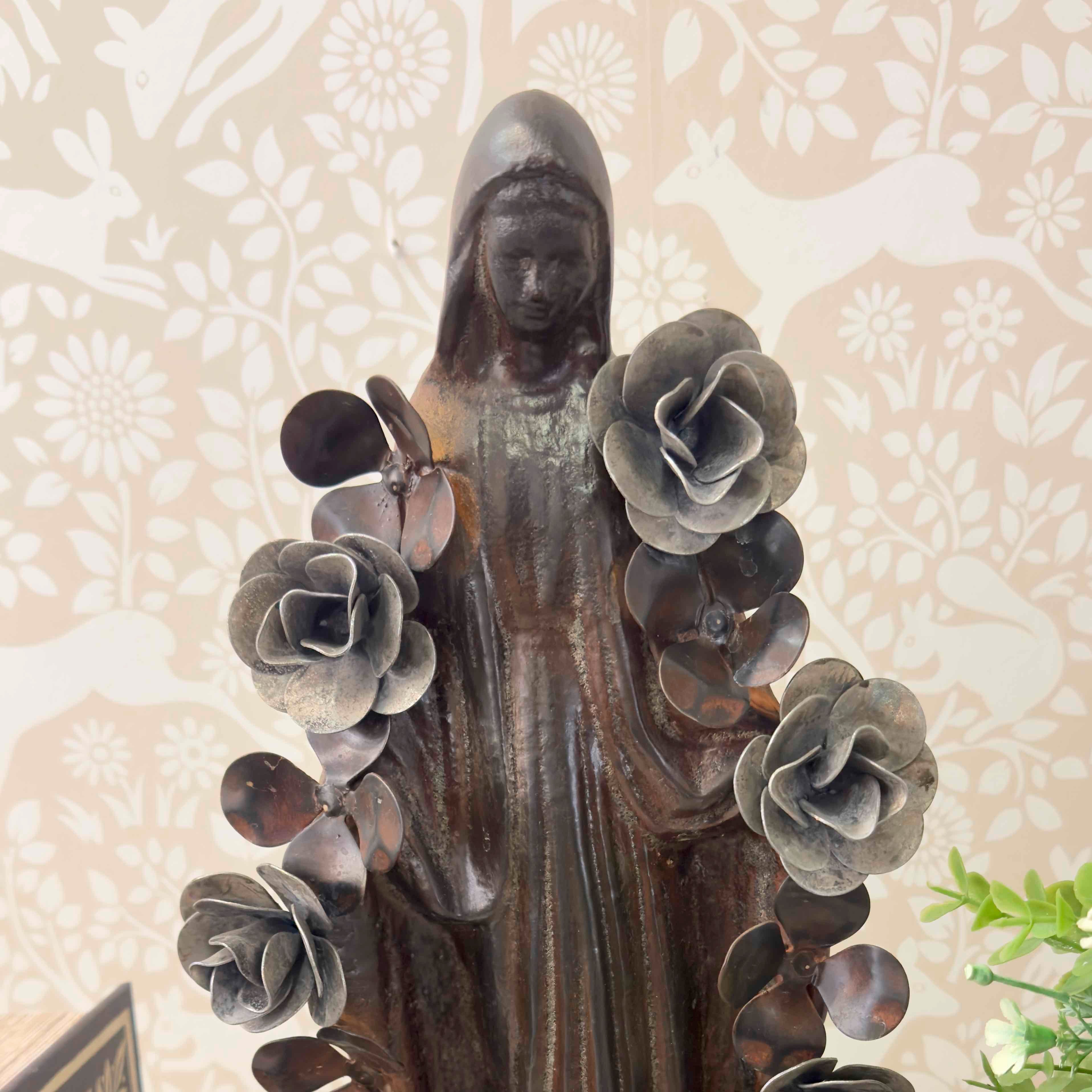Statue of a woman with floral elements against a floral-patterned background