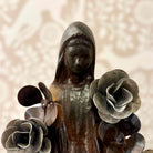 Statue of a woman with flowers against a textured beige background