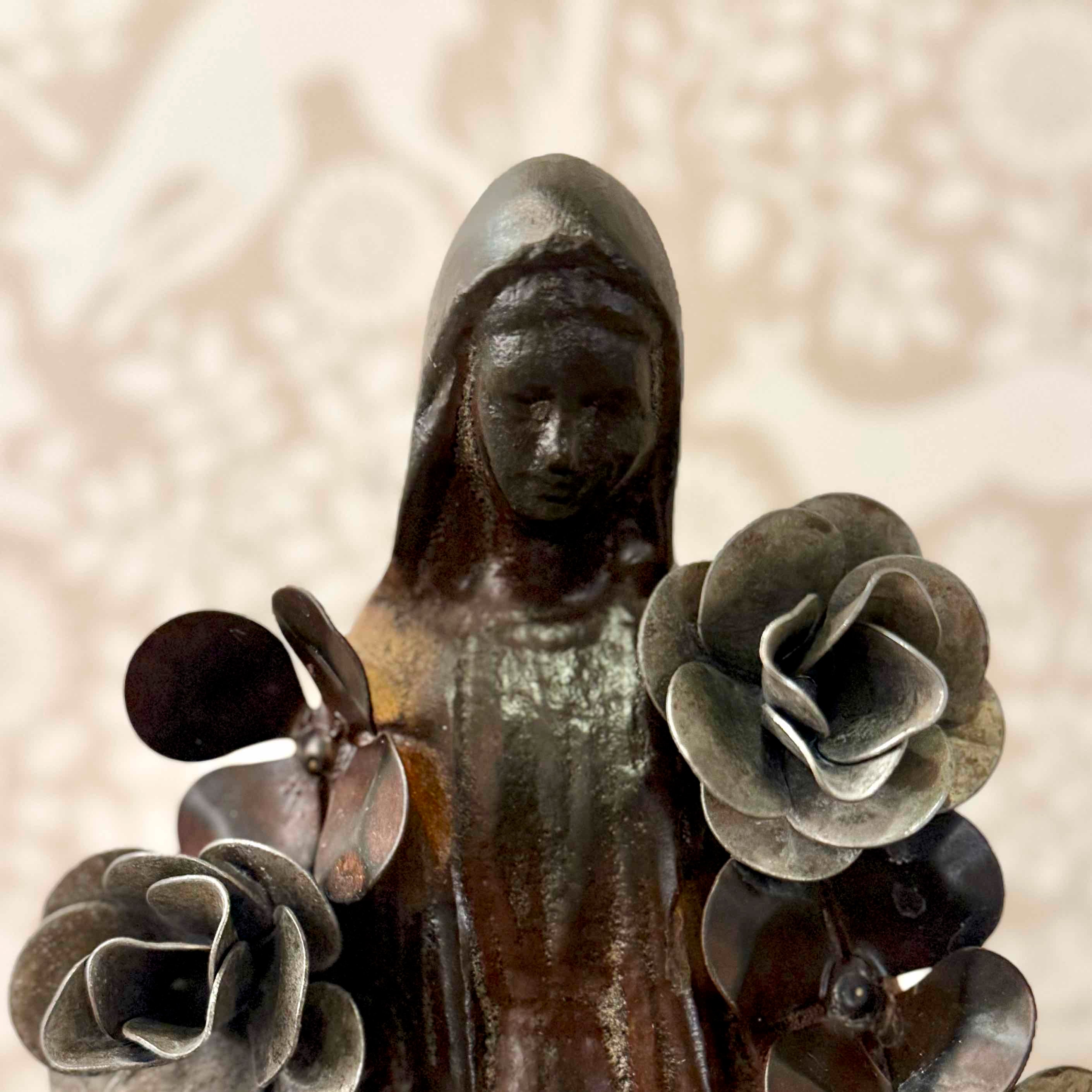 Statue of a woman with flowers against a textured beige background
