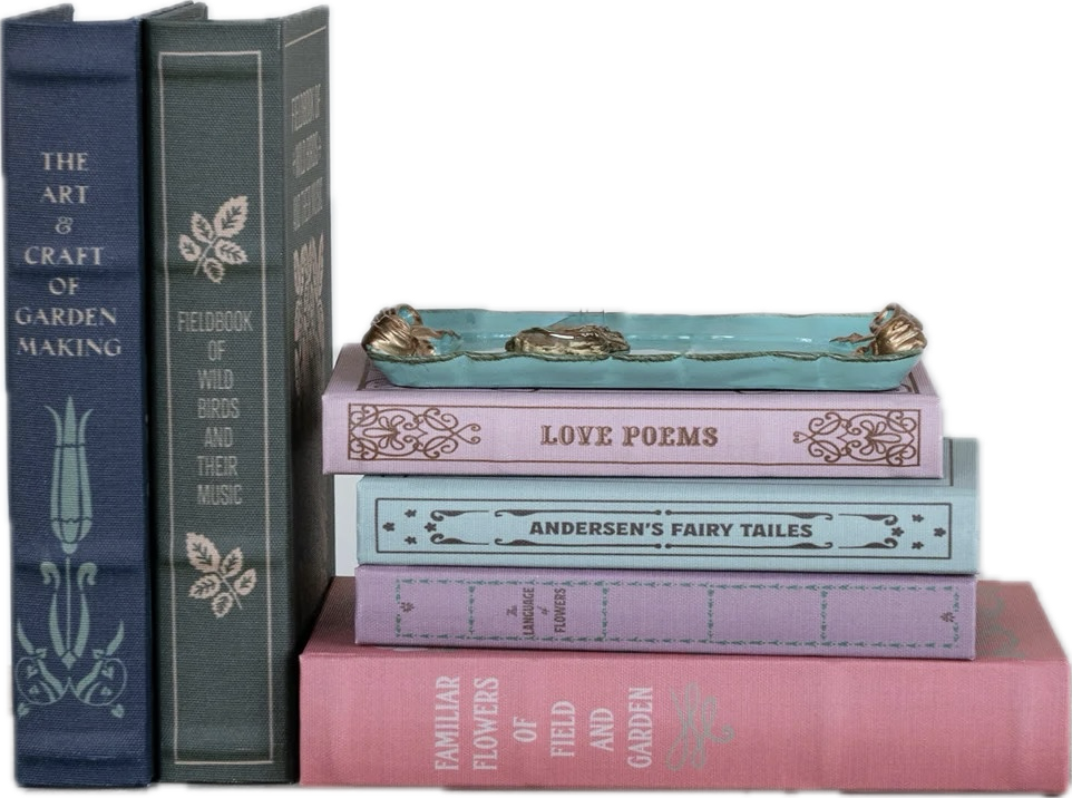 Stack of decorative books with a small tray on top against a white background