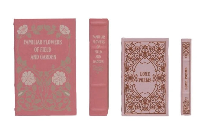 Set of decorative books with floral and text designs on pink backgrounds