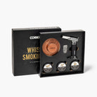 Whiskey smoking kit with wooden disc, metal tool, and labeled stones in a black box.