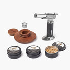 Smoking accessory set with a butane lighter, wooden components, and smoke flavor containers on a white background.