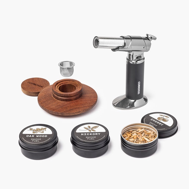 Smoking accessory set with a butane lighter, wooden components, and smoke flavor containers on a white background.