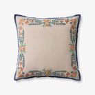 A square decorative throw pillow with a cream center, a navy blue border, and embroidered floral and leafy patterns in orange, green, and blue along the edges, shown on a light gray background.