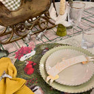 Decorative table setting with floral and nature-themed plates, glasses, and napkins.