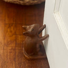 Wooden fox figurine on a wooden surface next to a white door