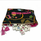 Colorful bag with 'Bespoke Mahjong' text and dominoes spilling out on a white background