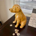 Dog-shaped piggy bank with coins on a surface