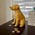 Dog-shaped piggy bank with coins on a surface