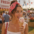 Woman enjoying an ice cream cone at a fair with a Ferris wheel in the background