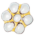 Ceramic egg tray with yellow border and white interior on a white background