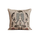 A square decorative throw pillow with an embroidered marine life pattern, resting on a rustic wooden surface against a textured beige wall.
