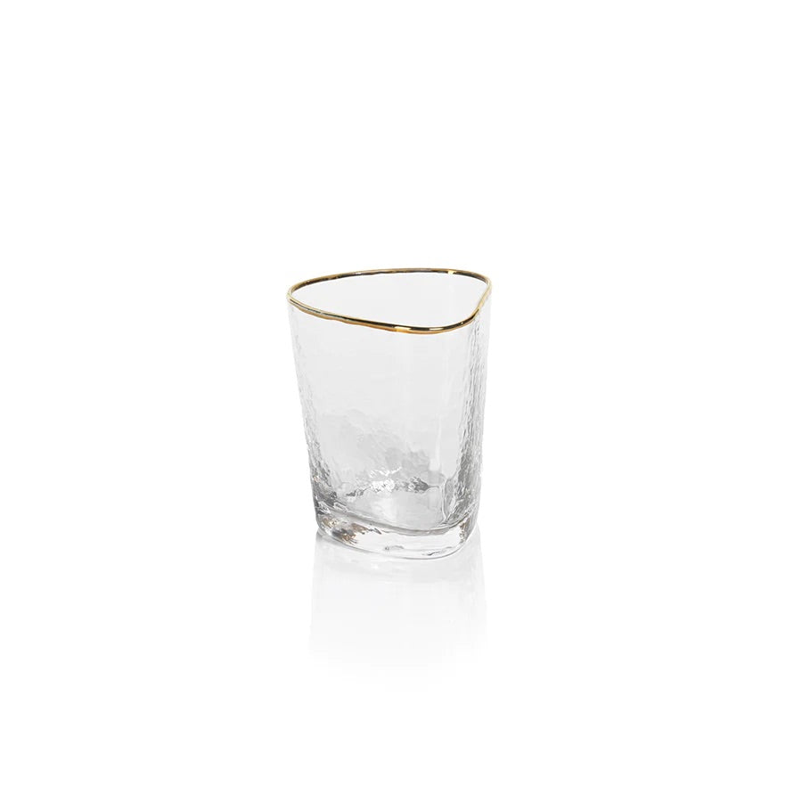 A clear triangular old fashioned glass with gold trimming on the rim.